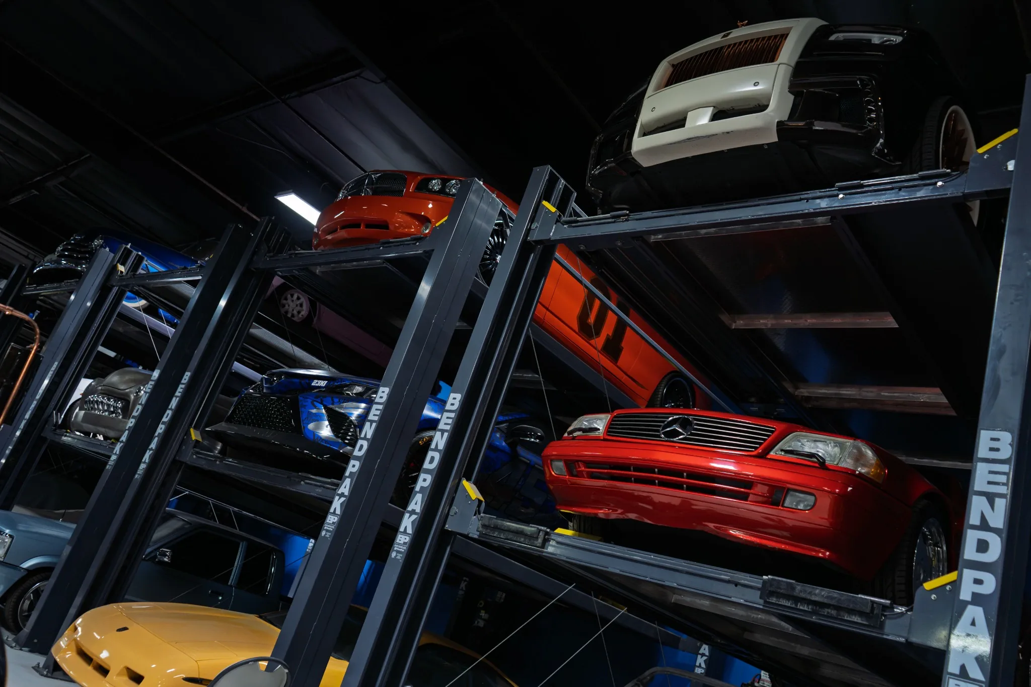 Vehicle collection on storage lifts at West Coast Customs